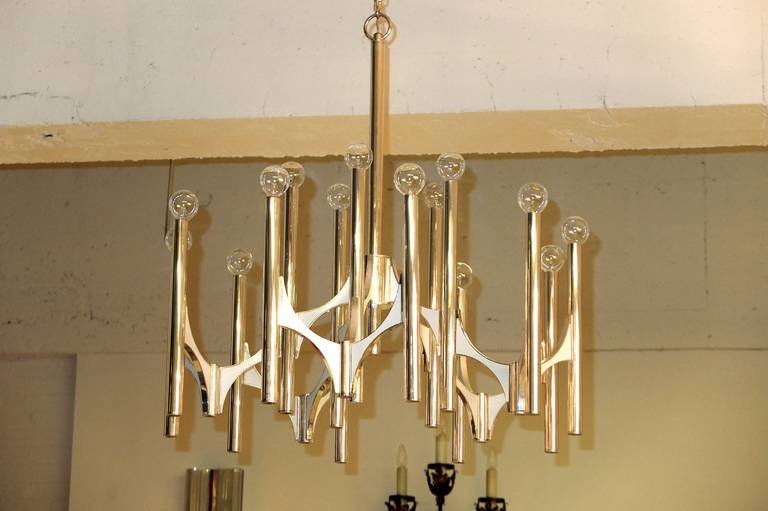Modern brutalist 15 bulb chandelier designed by Gaetano Sciolari for Lightolier made of vertical chrome tubes, brushed aluminum arches with white enamel embellishments.  30