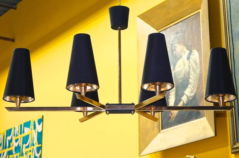 Clean lines on a horizontal plane from this six light linear form French 1950'a brass chandelier shown here with optional custom black uno ring shades with gold paper inside, handmade in France (additional $600 Net) or alternatively see image 8 for