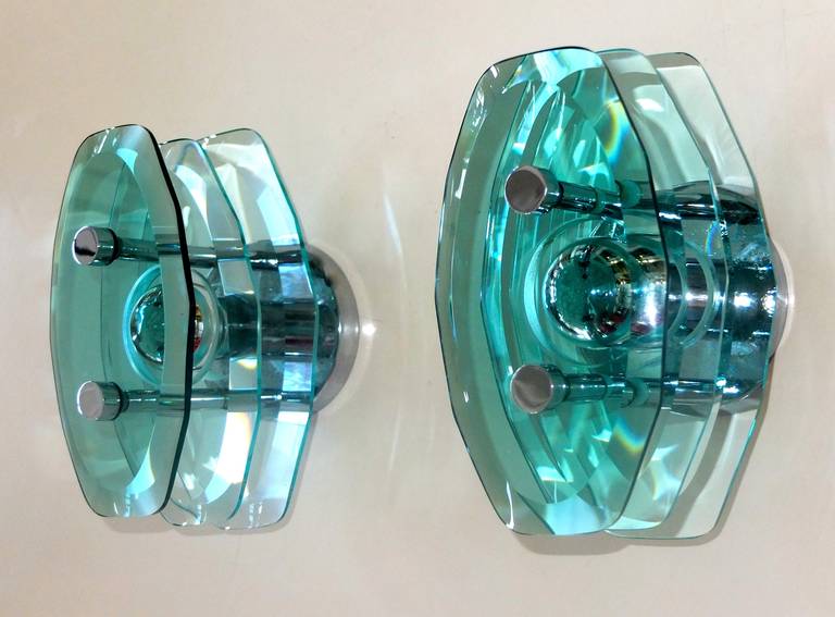 Pair of modernist appliqués from Italy circa 1960 by the firm CristalArte using three faceted cuts of aquamarine tinted crystal with chromed elements and hardware.