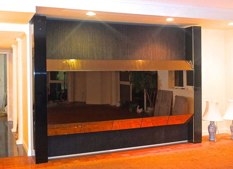 Horizon Electronic Wall designed by Cy Mann through Cavallon Associates, New York, circa 1980.  Remotely controlled panel of bronzed mirror raises and lowers revealing various open cabinet spaces for dry bar, flat screen television, glass ware and