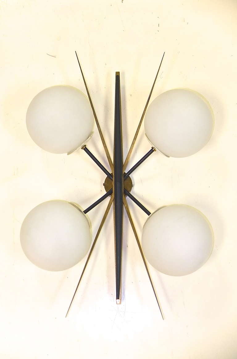 From Maison Arlus, France comes another fabulous creation…a hub cluster with multiple textures and materials; brass, steel, aluminum, walnut. Four satin glass orbs each cover a single candelabra bulb socket.

We have several pieces from this same