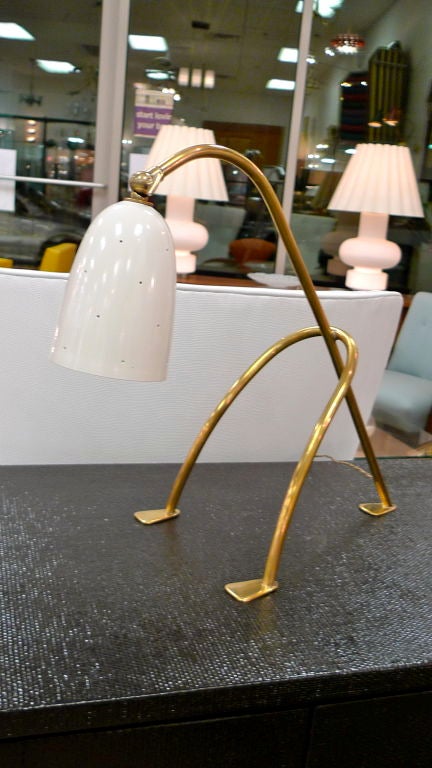 They should make a Disney movie staring this enchanting creature! Grasshopper style brass tripod legs with perforated white enameled cone/shade which articulates.  Probably by Angelo Lelii.