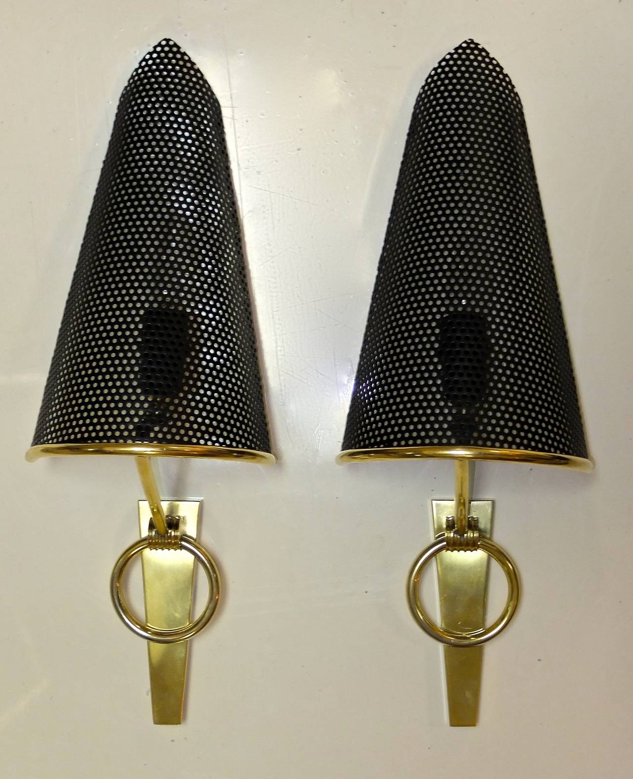 Pair of 1950's French wall sconces with hemi-conical shades made of perforated metal.  Produced for Lunel by Royal Lumiere circa 1953.  Rewired for USA with phenolic single socket for a candelabra bulb up to 60 watts each.