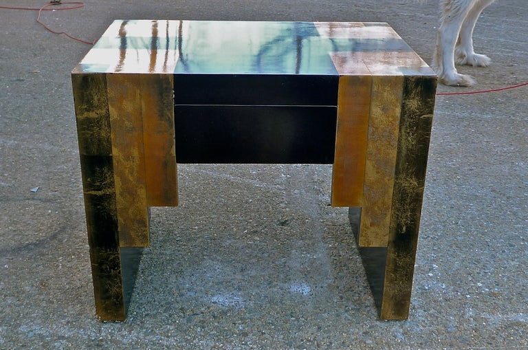 Lavishly lacquered and leafed rectangular occasional table with streamline art deco skyscraper stylings by Phyllis Morris.  Front side has single hidden drawer.