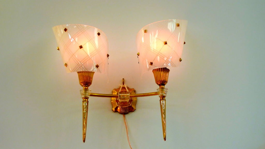 Glamorous vintage French wall applique consisting of dual mini-torch lights in gold tone brass with lucite fittings and gold studded bakelite or plexi shades. SImilar to the designs of Guariche.