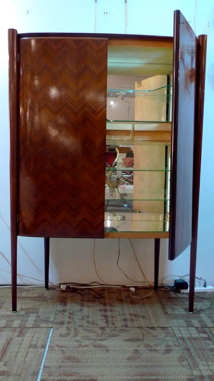 Exceptional Italian Art Moderne Bar Cabinet by Paolo Buffa, Designer and Architect (1903-1970).<br />
<br />
The slightly curved front body with rounded sides and balustrade is raised on long circular tapered legs which extend the entire length of