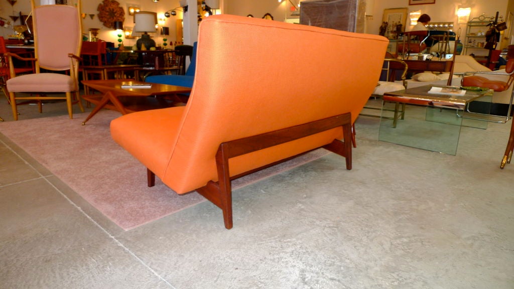 One of the loveliest and most comfortable sofa designs ever.  This two seater settee has just been upholstered in a linen blend in orange sherbert.  The color looks great with its sculptural walnut external frame.  <br />
Note, we also have the