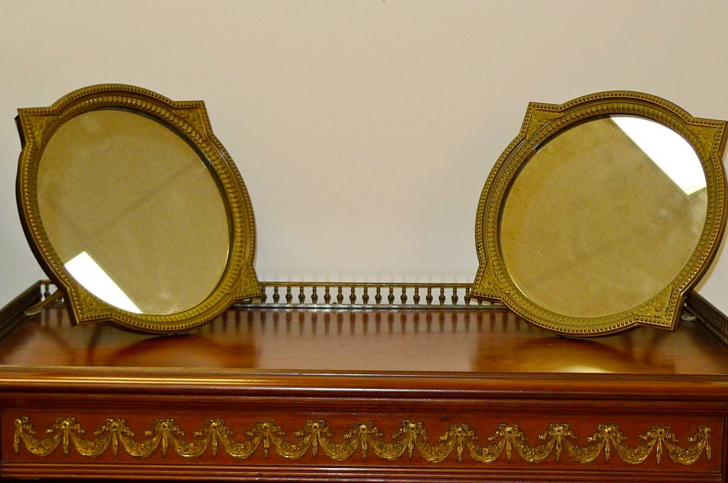 Pair of gilt bronze French table mirrors for a vanity or for hanging on a wall.<br />
<br />
Price is for the pair.