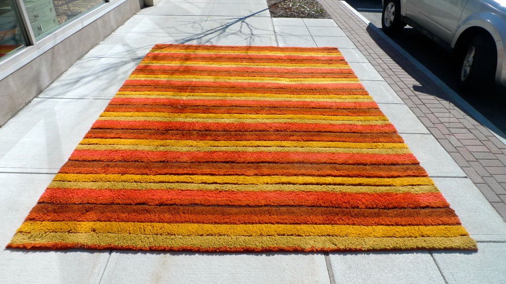Shagadelic early 1970's striped wool rug from the Chicago Merchandise Mart.  Orange, red, yellow, tan.

9 feet by 12 feet. WOuld fit perfectly with Adrian Pearsall decor.