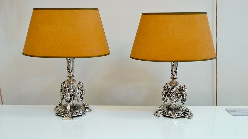 
Pair of mid-19th century nickel electroplated candle holders which had previously been converted to electric lamps during the first half of the 20th century (probably the early 1930's). Three Griffin figures on tri-form base. Marked 
