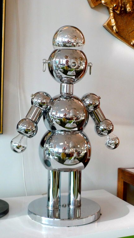 Italian Robot lamp by Torino in polished chrome. Head and hands light independently via the three way light switch which serves as the nose. Lucite eyes glow when illuminated.  Torino label present.