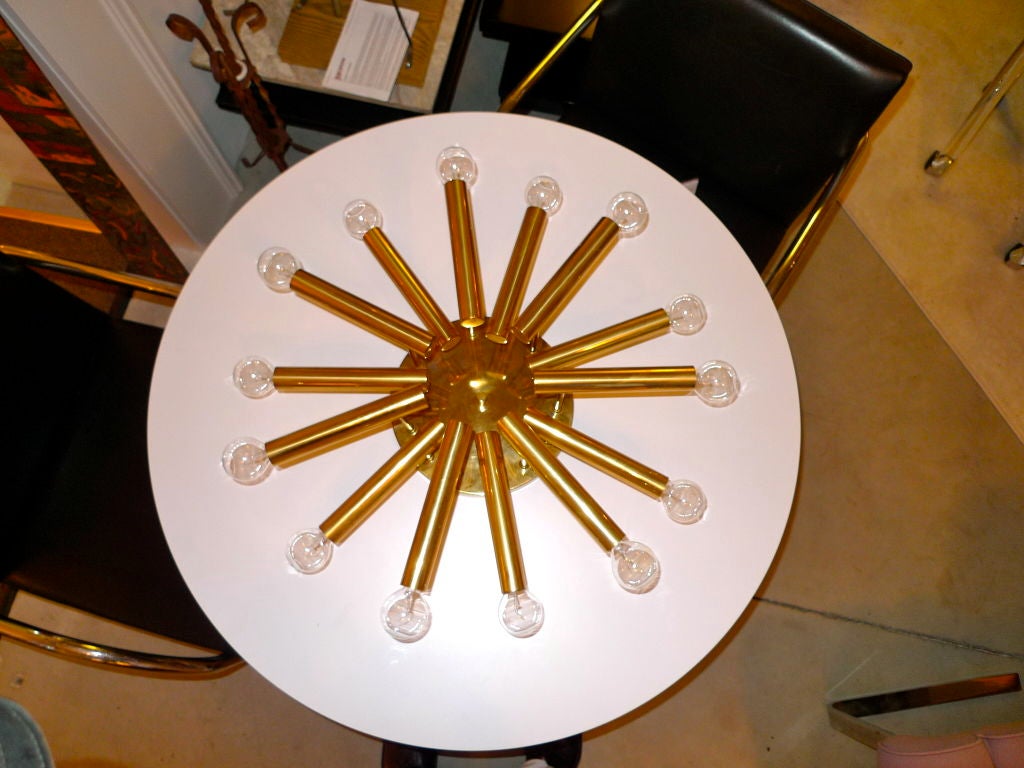 Flush mounted ceiling light fixture by Stilnovo with 14 brass tubes each ending in a single socket for a candelabra bulb.

I happen to have it mounted on my wall as a giant sconce and it looks amazing. Like a cigar Sputnik.