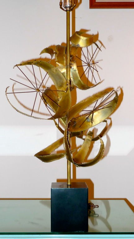 Bijan of California for Laurel titled “Setarrah”. First appearing in the Laurel Lamp Co catalogs in 1968. 
Large scale sculptural table lamp consisting of torch cut brass cactus leaves and star shaped wire on a black cube base made of enameled