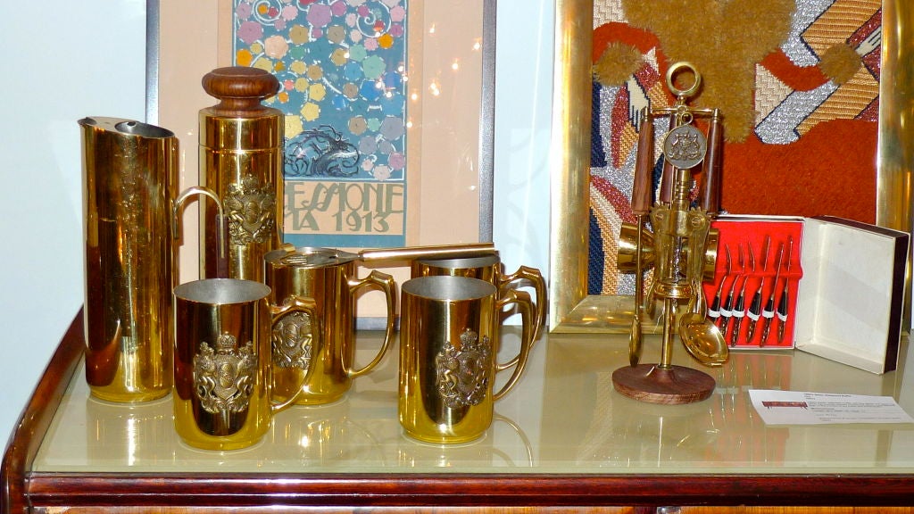 Ein stilvolles Set aus italienischem Bargeschirr aus Messing, bestehend aus vier Krügen mit aufgesetztem Wappen, einem Shaker, einem Krug und einem drehbaren Ständer mit Korkenzieher, Flaschenöffner, doppeltem Schnapsmesser und Löffel.  <br />
<br