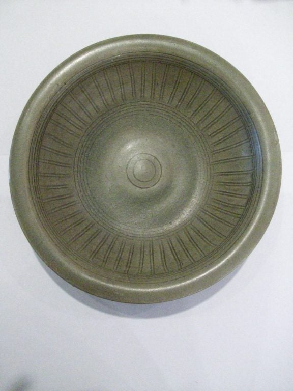 Celadon glaze stoneware bowl from the Sawankhalok region of northern Thailand.  The glaze contains small mica chips that are difficult to capture in photos - but catch the light and shimmer beautifully in person.  The linear design uses cosmic