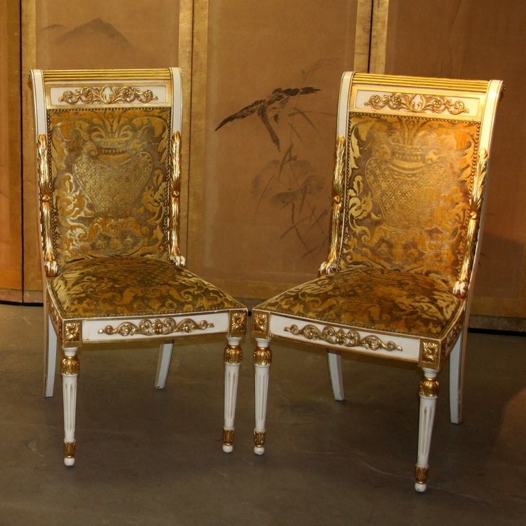 Neo-Classical style chairs, in gold and ivory lacquered wood.
Barocco velvet which brings a colorfull and rich feeling to these elegant and exceptional pieces.
Sword shaped back legs,full Empire style, great curved lines from the back joining to