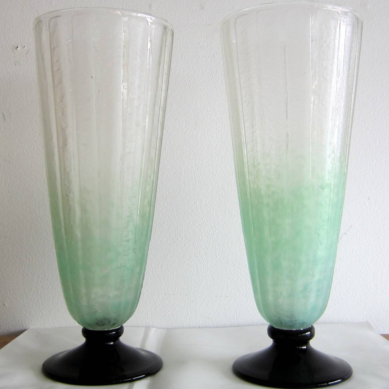 Art Deco Pair pale green frosted glass  vases signed by Charles Schneider.
Standing on a dark purple base, almond green and white top.
Elegant shape.