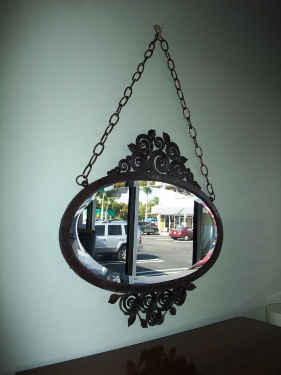 Extremely refined iron piece. This oval Art Deco Mirror is a very interesting work of this period .The stylized spiral shape of each motif is perfectly organized on both side, the top and the bottom of the oval design. The quality of the iron work