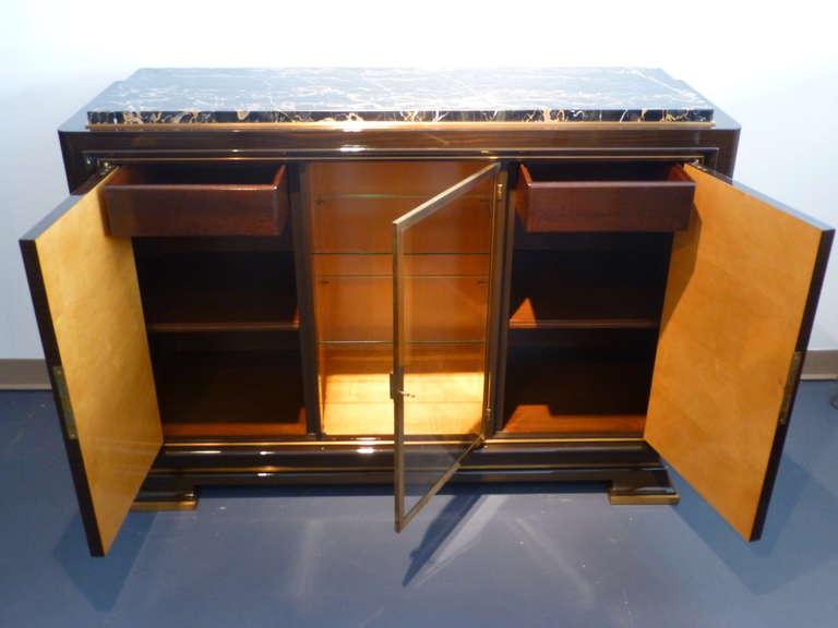 Elegant piece of furniture in rosewood (sycamore on the inside). Perfect proportions. The middle part is a vitrine with two glass shelves and every side part has a shelf and a drawer on the top. Italian 