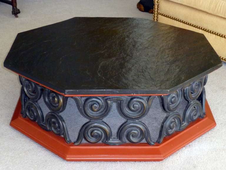 Wide and very interesting designed coffee table. 
The top is a natural slate stone piece.
The base is in red lacquered wood, the middle part of the base is made of iron.
The waves design of the iron brings an interesting light aspect to the