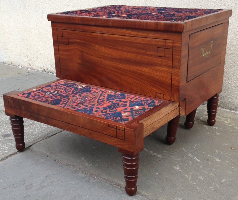 A satinwood box on turned legs, which opens to two steps covered in Kilim carpet from the early-19th century. 