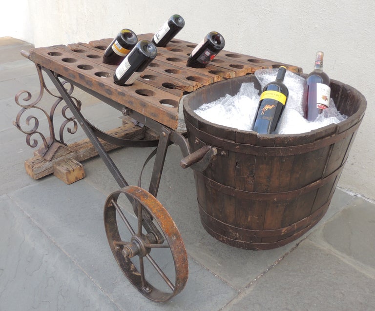A wonderful and very unusual wine cart from France. All elements of this piece are from the 19th century, but have been assembled in the 20th century. A wheelbarrow carries a French grape bucket, while a wine bottle rack lies over the handles.