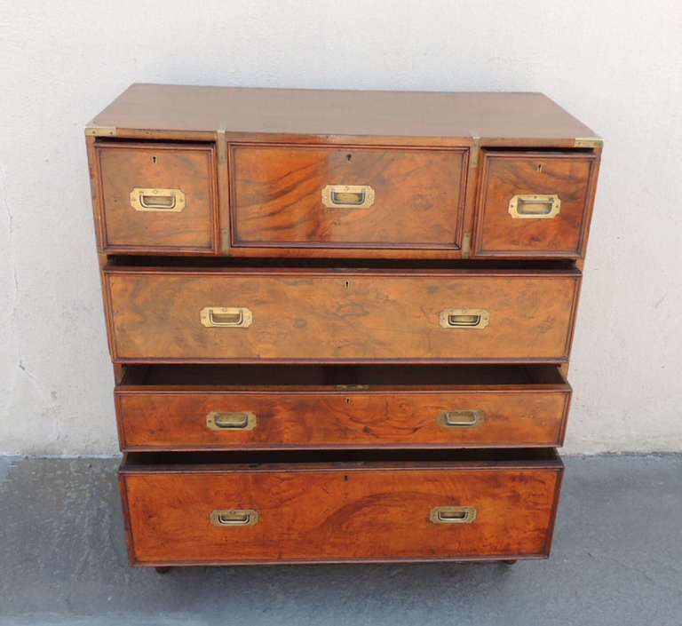 This rare piece has a walnut front with mahogany secondary and oak interior. There are five drawers and a butlers secretary desk with nine original brass handles and brass detailing on the sides. The removable peg feet are hand-turned. The maker of