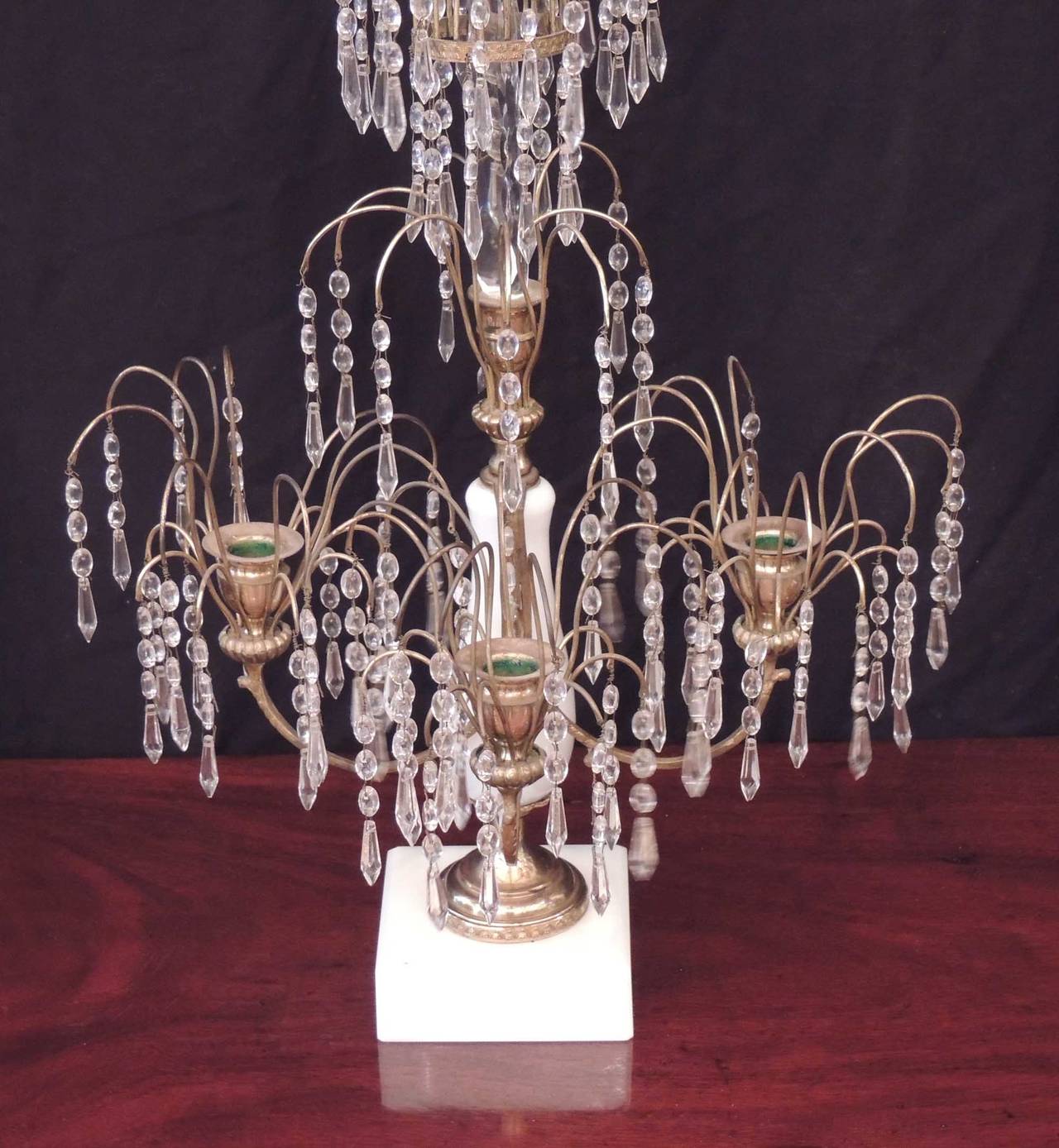 These French crystal candelabras were made in the 1840s. The pieces have marble bases, opaline glass stems, three candle arms each, and a truly grand amount of crystal drops, which are sure to catch the light when lit.