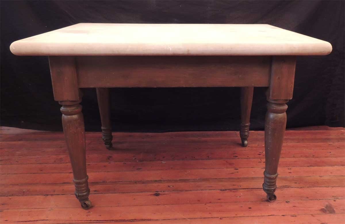This table was made in the American South in the early 19th century, circa 1830. This table is faux-grain mahogany over yellow pine. This table features the original massive white marble slab top, hand-turned legs, and original casters.