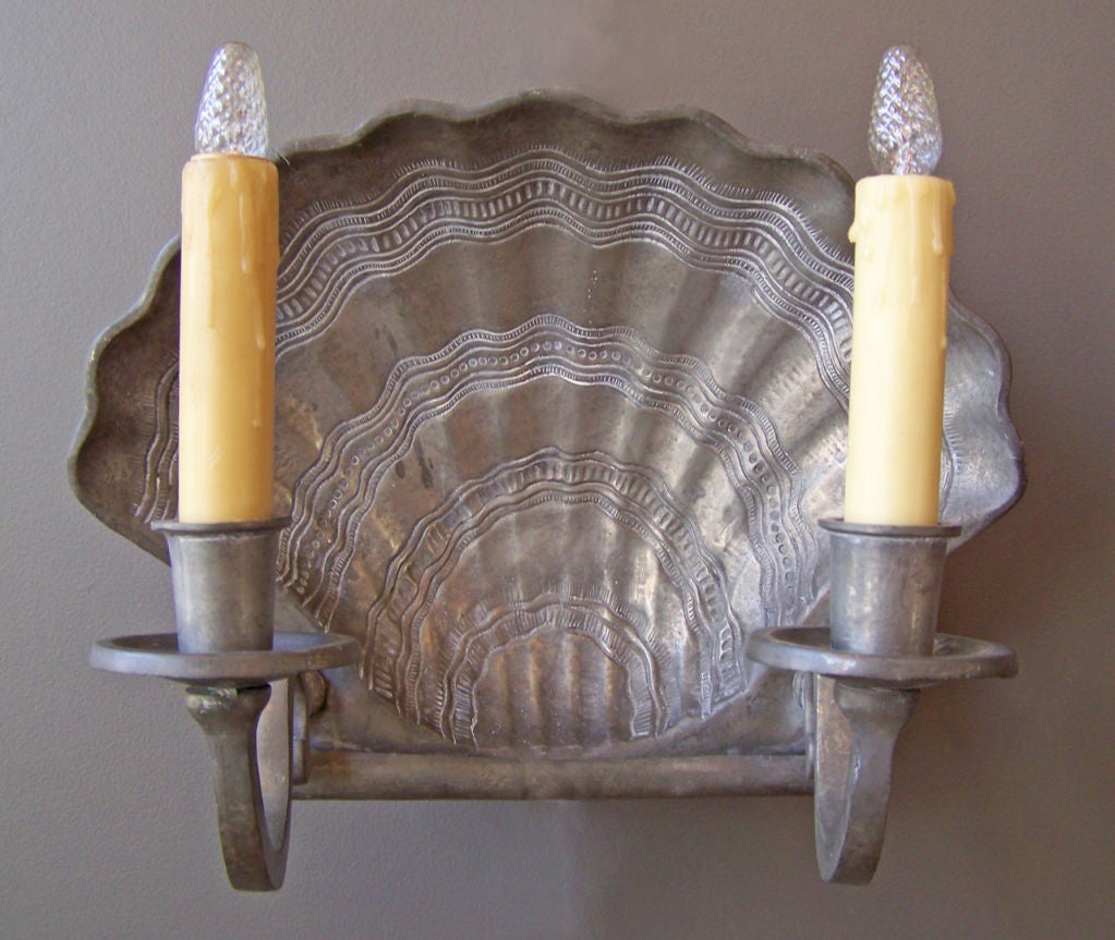 A decorative pair of two-arm pewter sconces in a scallop shell motif. Makers stamp on reverse.