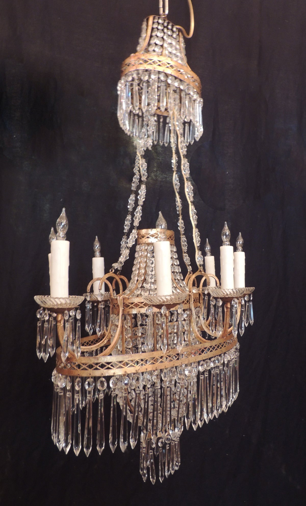 This unique chandelier was made in Italy during the first half of the 19th century and is a rare elliptical shape.  This piece features an urn-shaped middle section made of etched and pierced tole borders with crystal beading surrounded by a larger