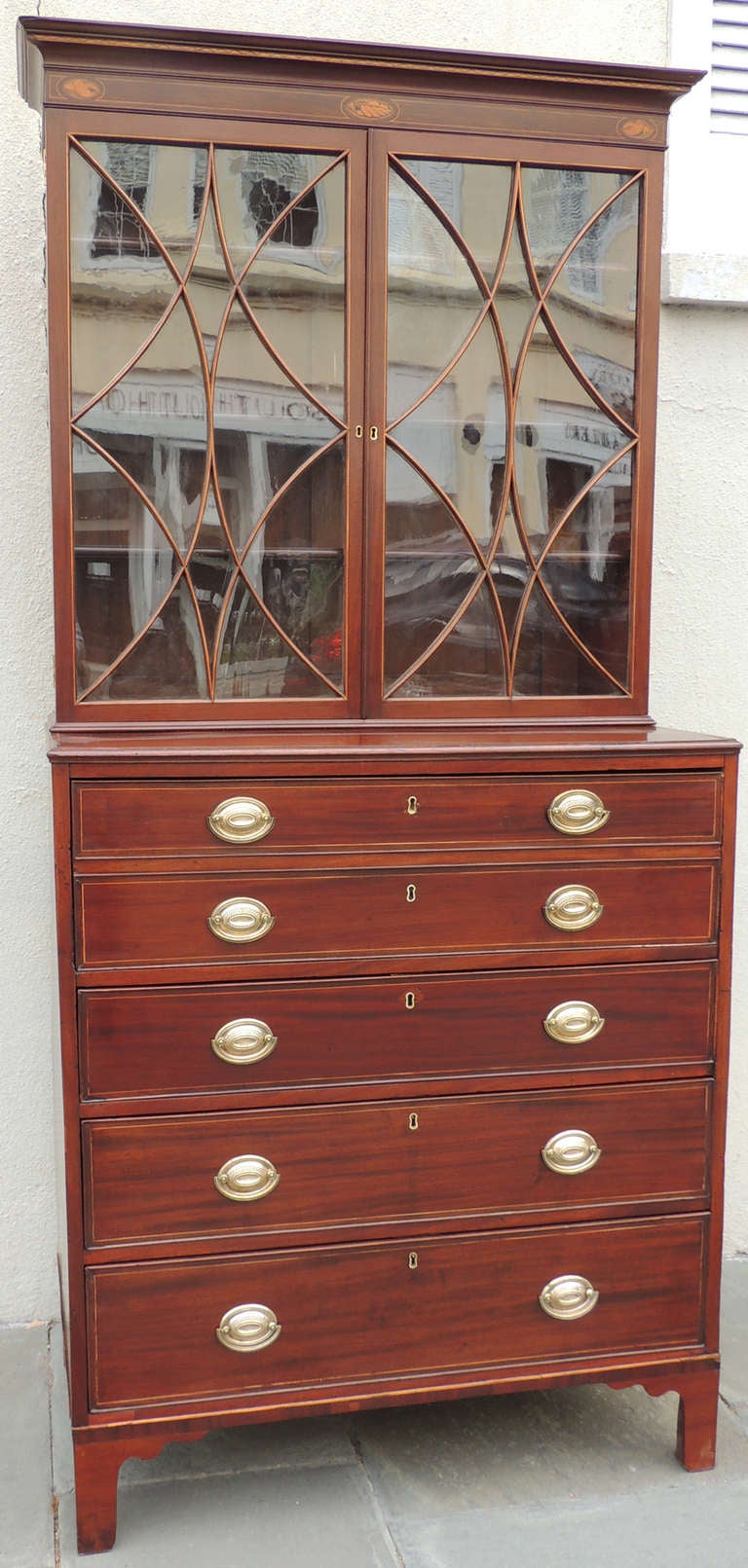 A wonderful early 19th century butler's secretary from England. This piece features drawers for storage, and a secretary element in the top two drawers. A felt writing space and multiple satinwood drawers, one with pistil in vase. The top portion of