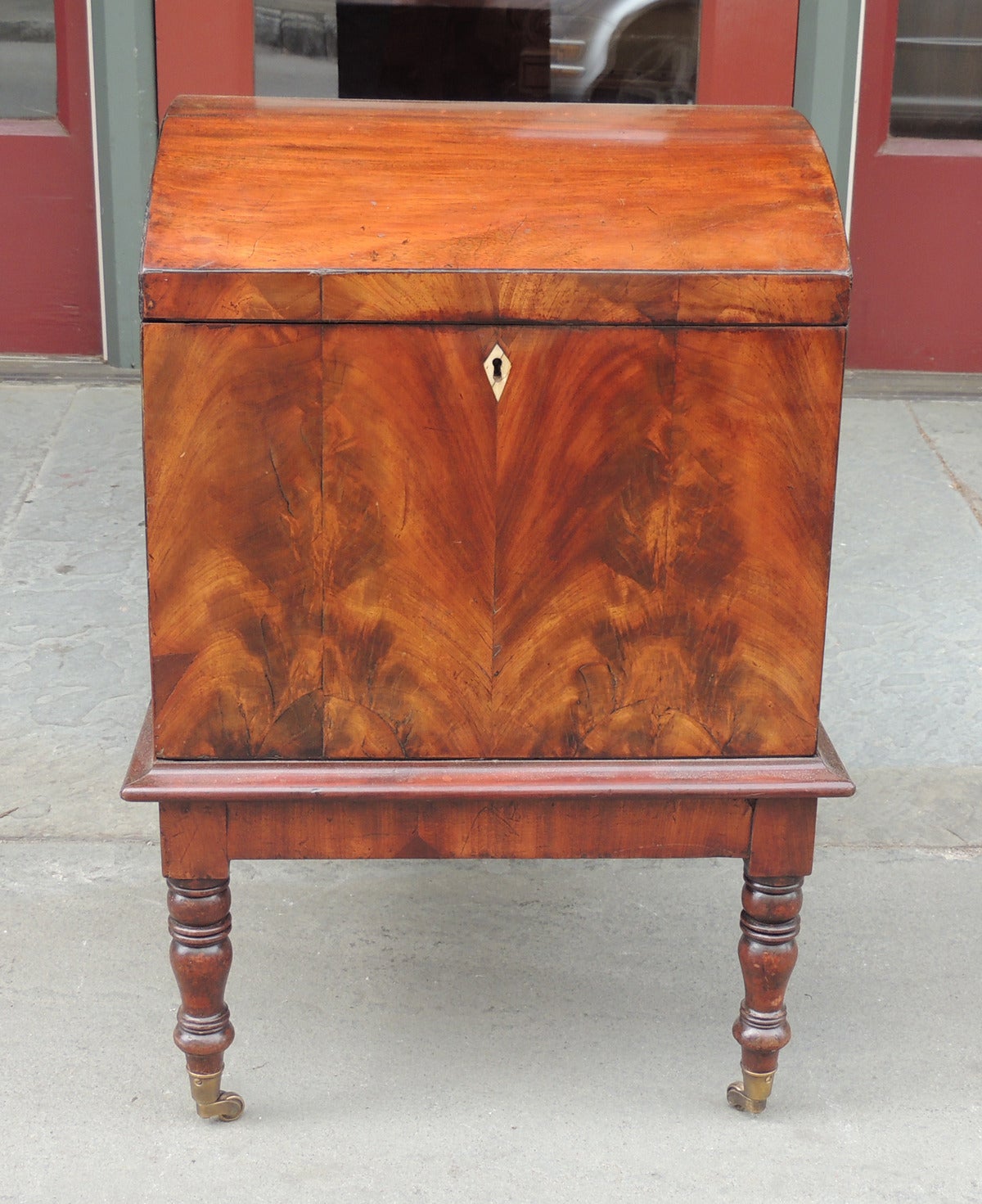 This cellarette was made in England, circa 1790. This piece is made with mahogany veneer and dil secondary woods. This cellarette features a dome top that opens to reveal nine sections for holding bottles. The bottom features a decorative lip above