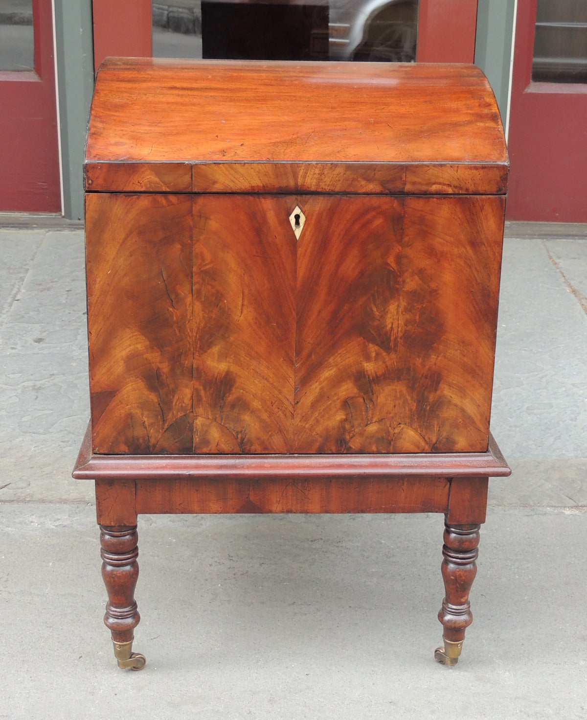 This cellarette was made in England during the 18th century, circa 1780-1790. This piece features a dome top the opens to several bottle slots. This piece is on four Sheraton turned legs with original casters. 
Pine secondary wood.