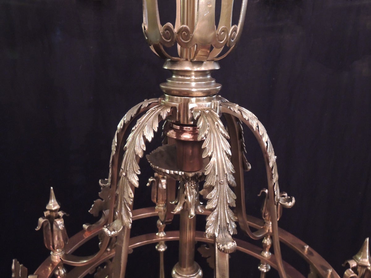 This monumental lantern is one of a pair and was made in New York during the first half of the 20th century. This lantern features a traditional shaped top with foliate finials. This piece has eighteen lights that with cast bobeches. The base of the