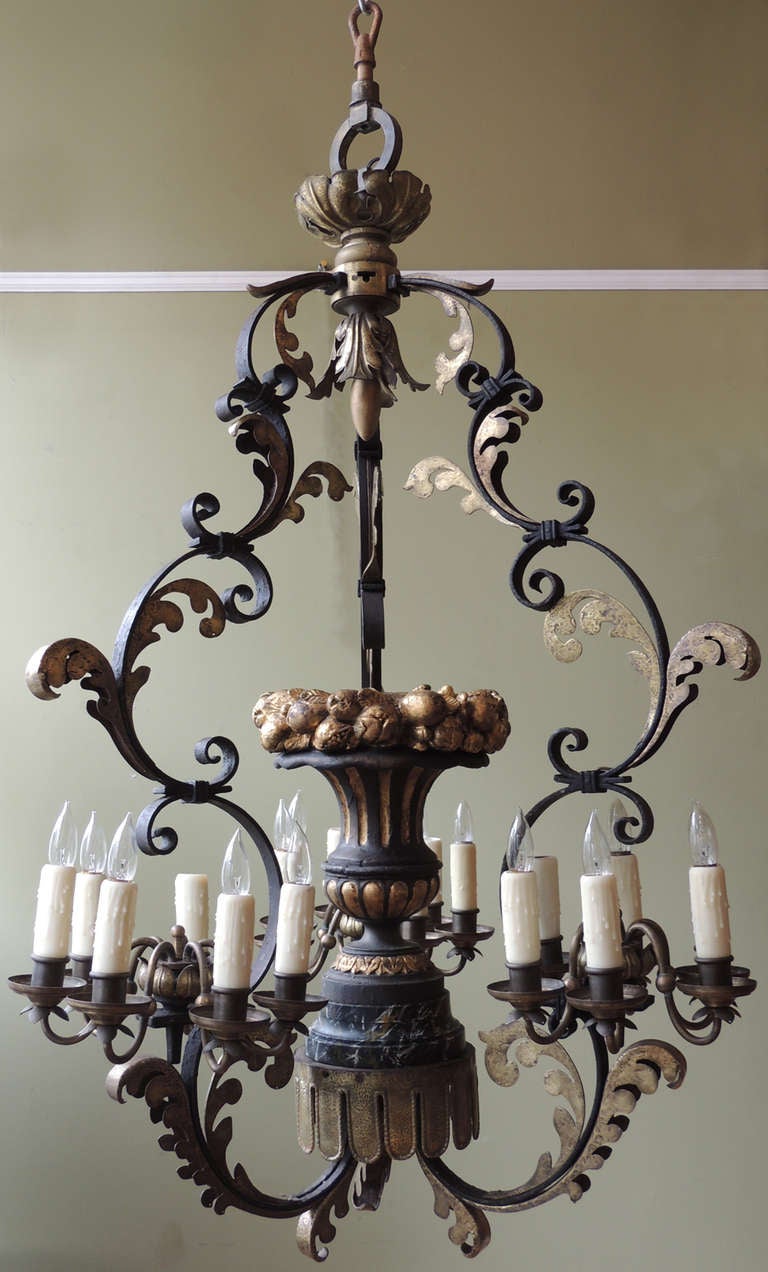 Pair of Italian chandeliers featuring curling foliage and three arms holding the lights; all made from brass and iron. 