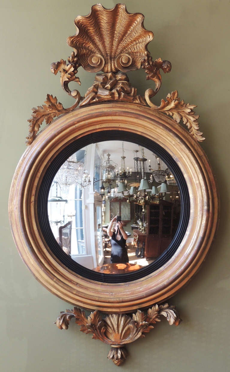 This mirror is truly one of a kind. While convex mirrors are fairly common, the shell motif makes this piece especially rare. This piece is English, from the 1820s, and features not only the large shell, but also a small scallop shell on the bottom,