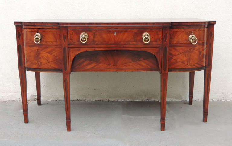 This beautiful sideboard was made in Scotland during the early part of the 19th Century, around 1800. This piece is made of mahogany with pine secondary. This item features a shell motif inlay in the center of the top. The four regency drawer pulls