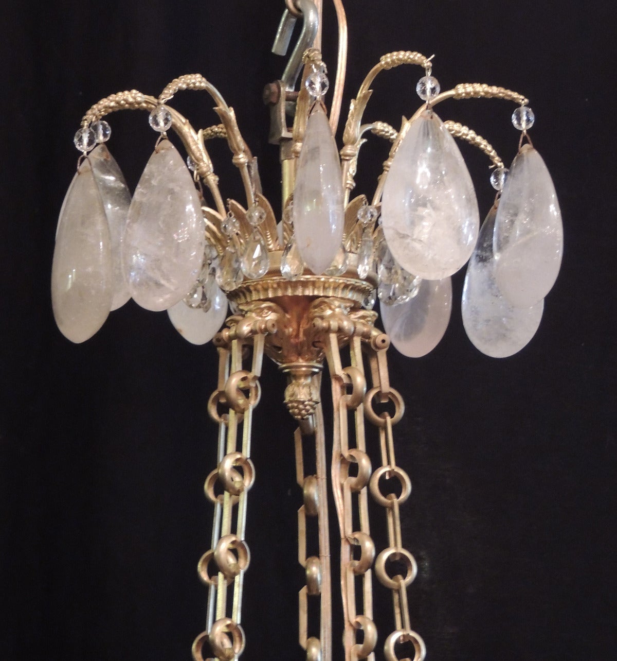 This unique chandelier was made in Russia in the first half of the 19th century, circa 1810. This fixture features a top canopy with small crystal prisms surrounded by large rock crystal prisms. The four bronze chains are suspended in the mouths of