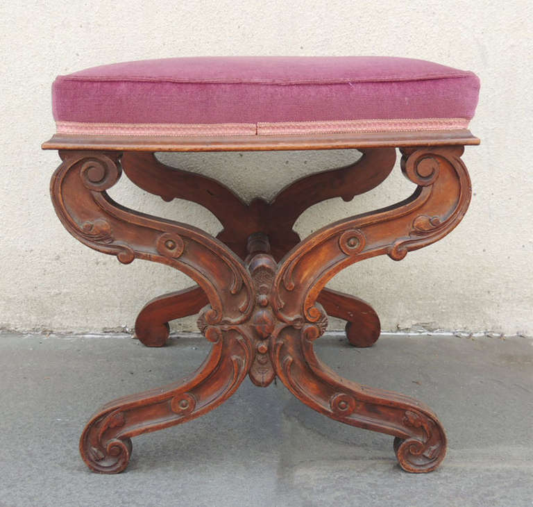 This English Regency bench was made in the late-19th century. The bottom features intricate carving of scrolls and circles with scroll foot. The center spindle is hand-turned with a center ball detail.