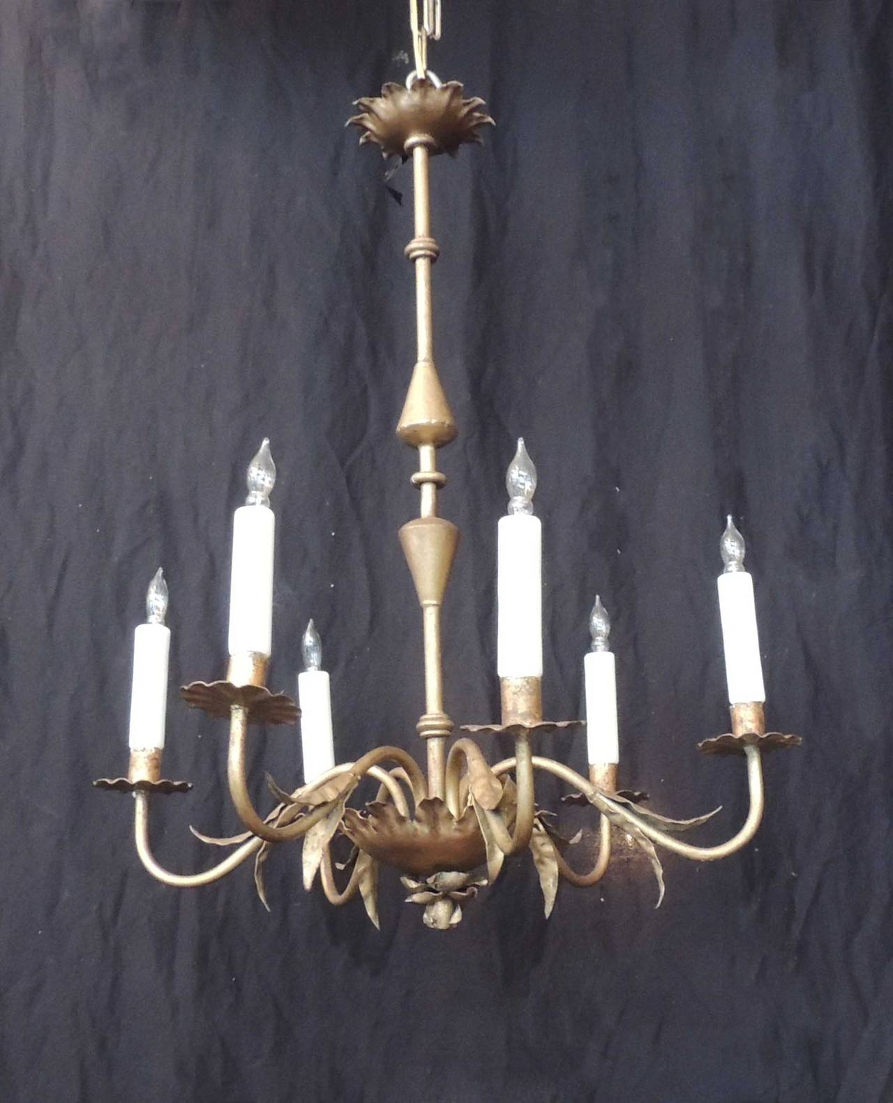 This Barcelona chandelier has a unique stem with six foliate arms, a floral base, and rippled bobeches. The boulbous stem with central ring connects to the floral base with rose petal detail on the bottom canopy. Above the bottom canopy there are