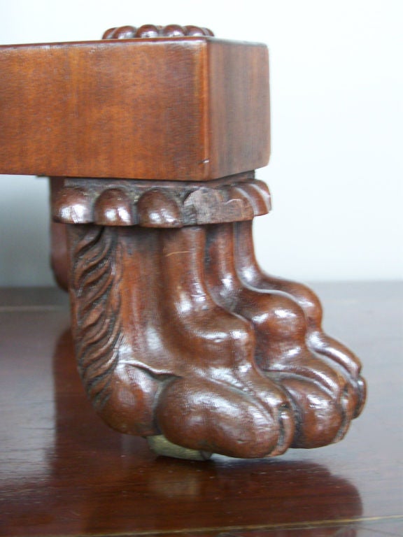 A beautiful mahogany teapoy with decorative empire claw feet and elegant carved elements down the support.