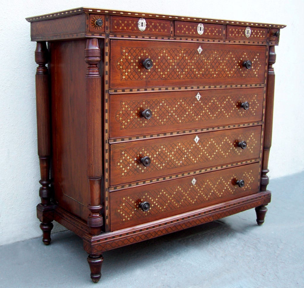 This rare chest evokes all that is unique in Portuguese colonial furniture. Exquisitely ornate with geometric patterns of ebony and ivory inlay complete with silver escutcheons. Turned and carved feet and collonettes complement the wonderful size