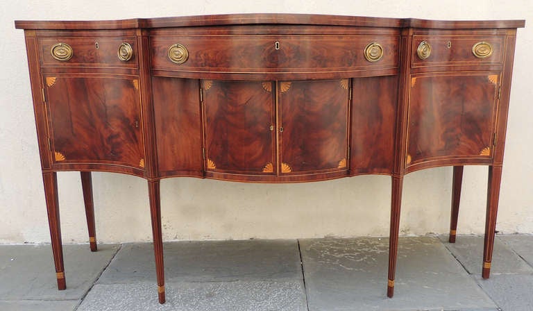This sideboard has mahogany primary with poplar and white pine secondary woods. 19th century script signature in chalk on the base reads, Daniel Young Provence. 
The corners of the inner doors feature a fan motif. The square leg have a ebony and