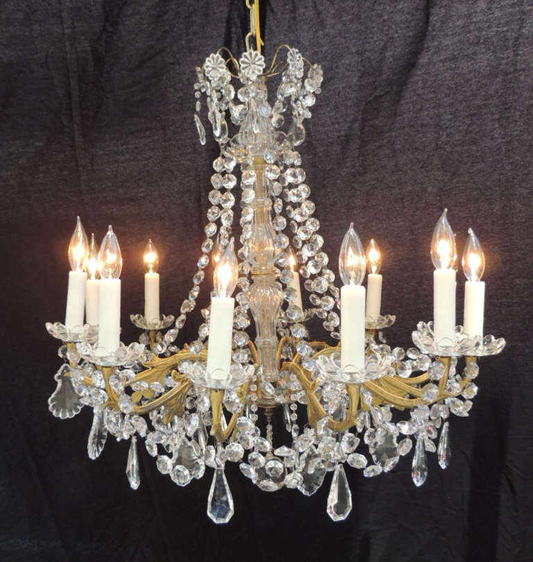 This chandelier was made in France during the mid-19th century, circa 1850. The base of this chandelier is bronze with intricate foliage casting on the middle section of the arms. The arms hold three levels of crystal-beaded swags each with tear