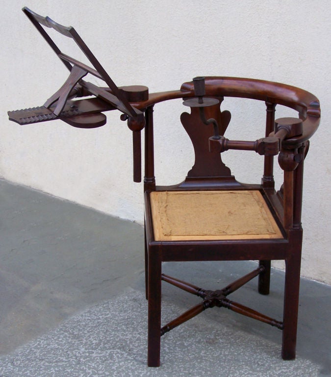 A unique 18th century mahogany metamorphic reading chair with detachable book and candle arms. The chair has a flat semi-circular top with an urn-shaped splat. An adjustable wooden candle arm with wooden drip bobeshe swings from the left arm of the