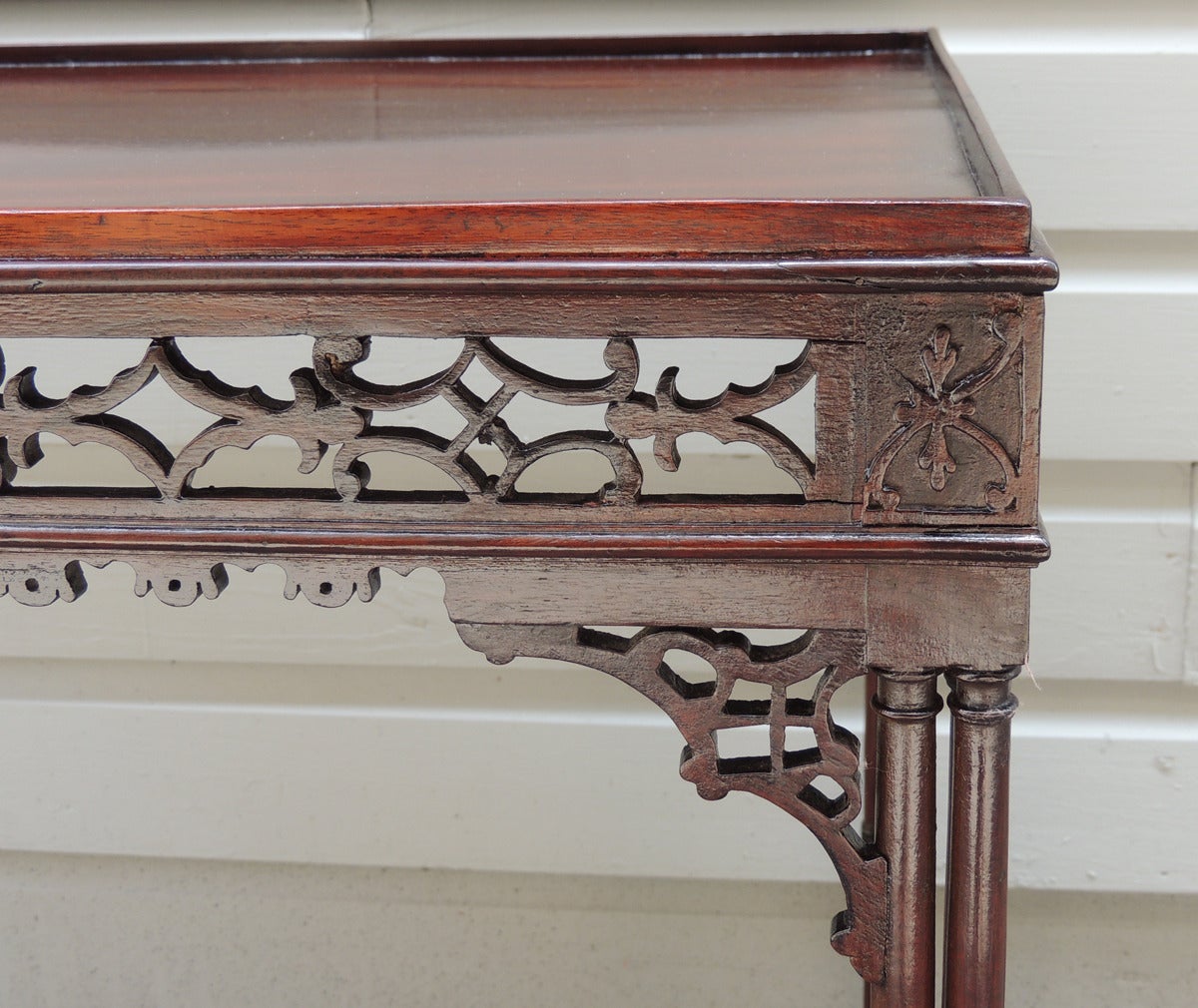 This mahogany Chippendale table was made in the late 18th Century. The table features carved Chinese fret work including a pierced apron sitting above pierced brackets. The legs are faux bamboo with rosette detail. The table is on the original four