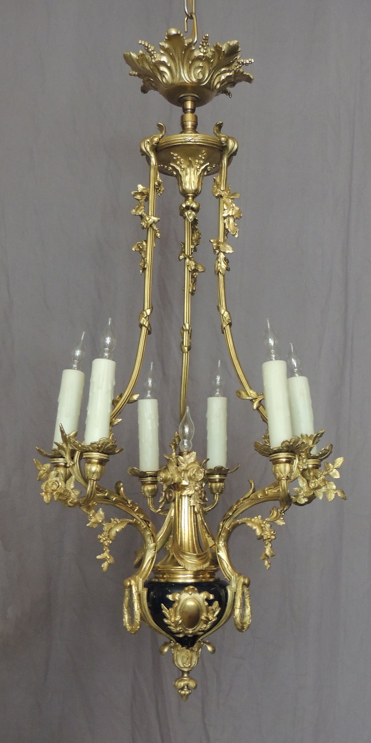 These four bronze chandeliers were made in France in the early-20th century, 
circa 1900, and are bronze doré with cobalt-blue bases and seven lights each.  The casting on these chandeliers displays foliate and floral motifs and are excellent