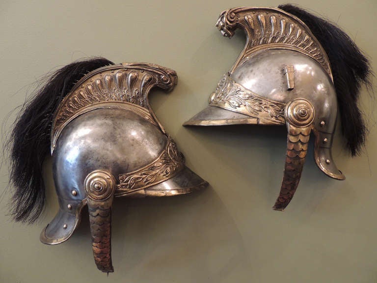 This traditional officer's helmet was created in France during the reign emperor Napoleon. This helmet was cut in half in order to be used as wall decoration. The piece features brass details on the top and sides of the helmet, the chin strap is