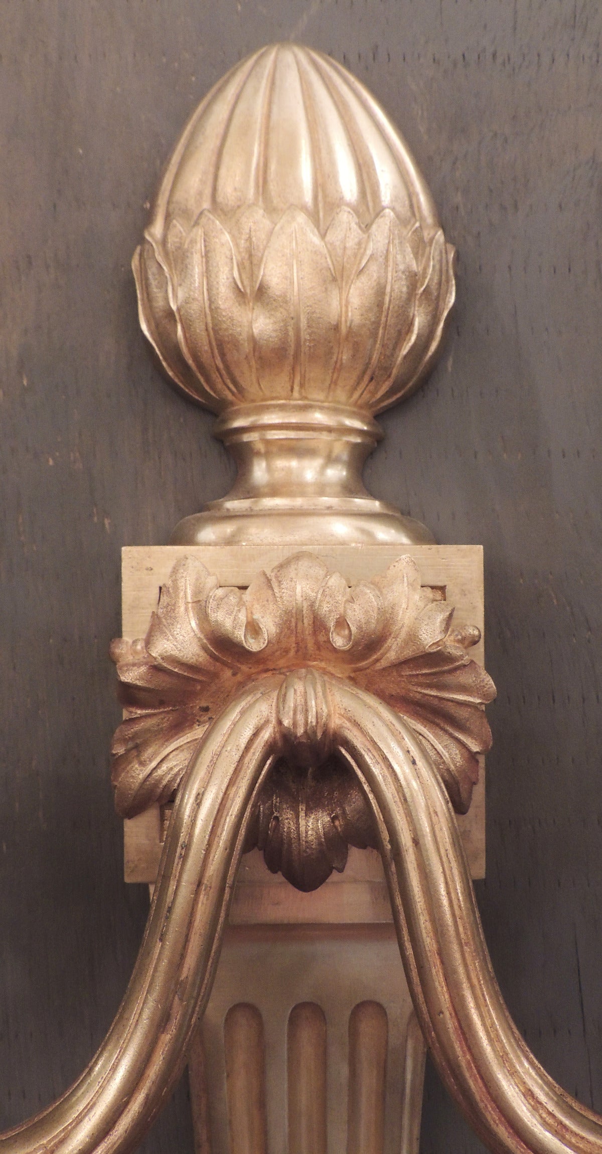 Cette paire de très grandes appliques en bronze doré a été créée en France au XIXe siècle, vers 1840. Cette paire comporte un épi de faîtage en forme de gland qui repose sur une colonne dorique à motif floral. Le fond est orné de feuillages et d'un